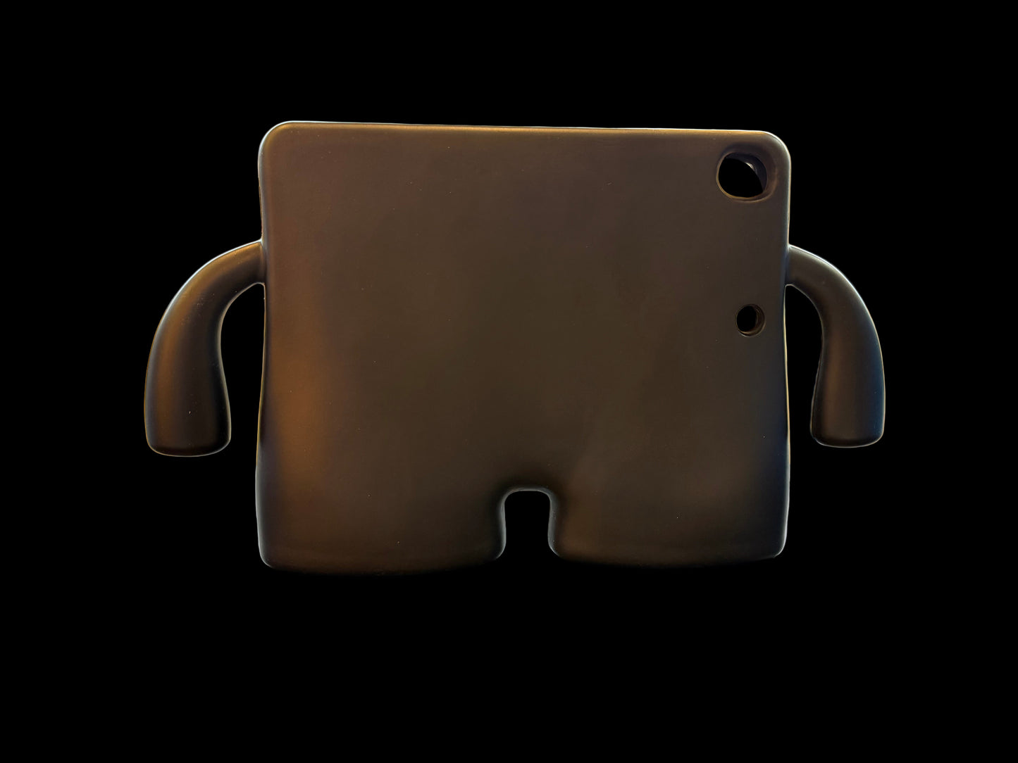 Black elephant-shaped cushion on a table with a store interior in the background